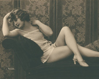 Image of  a flapper in a white chemise and high heeled shoes. 